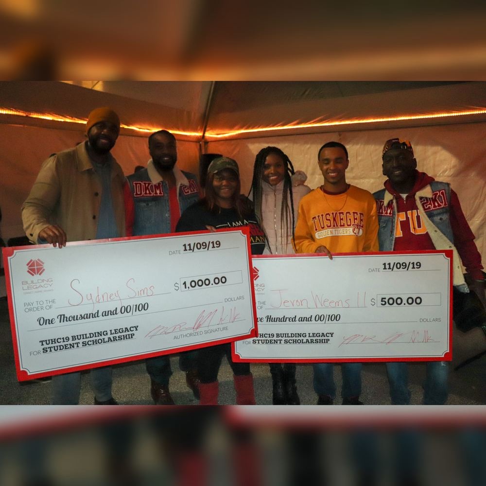 Two students receiving scholarship checks