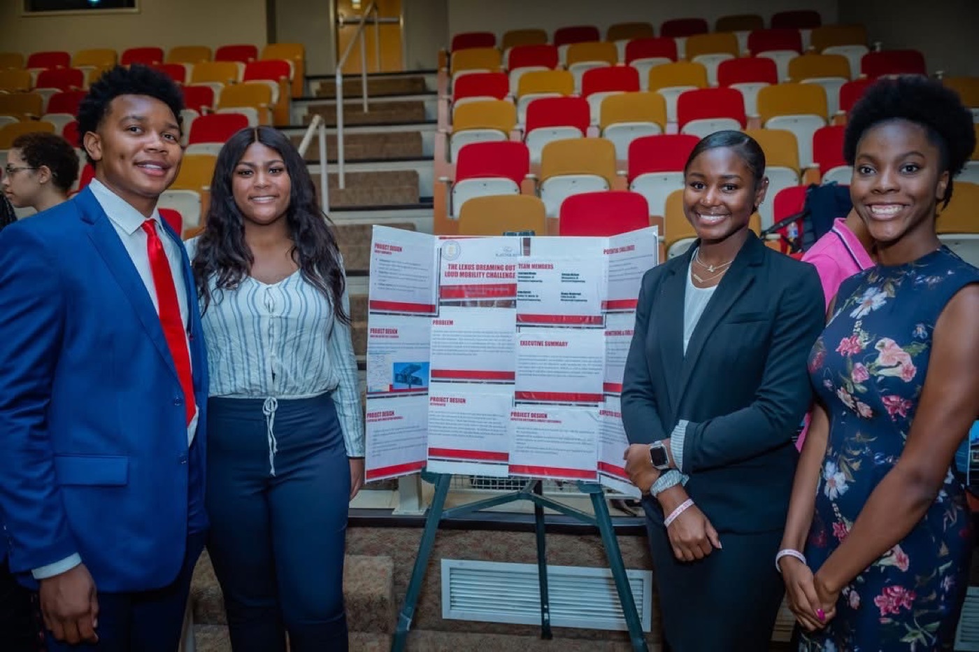Students standing beside their research poster
