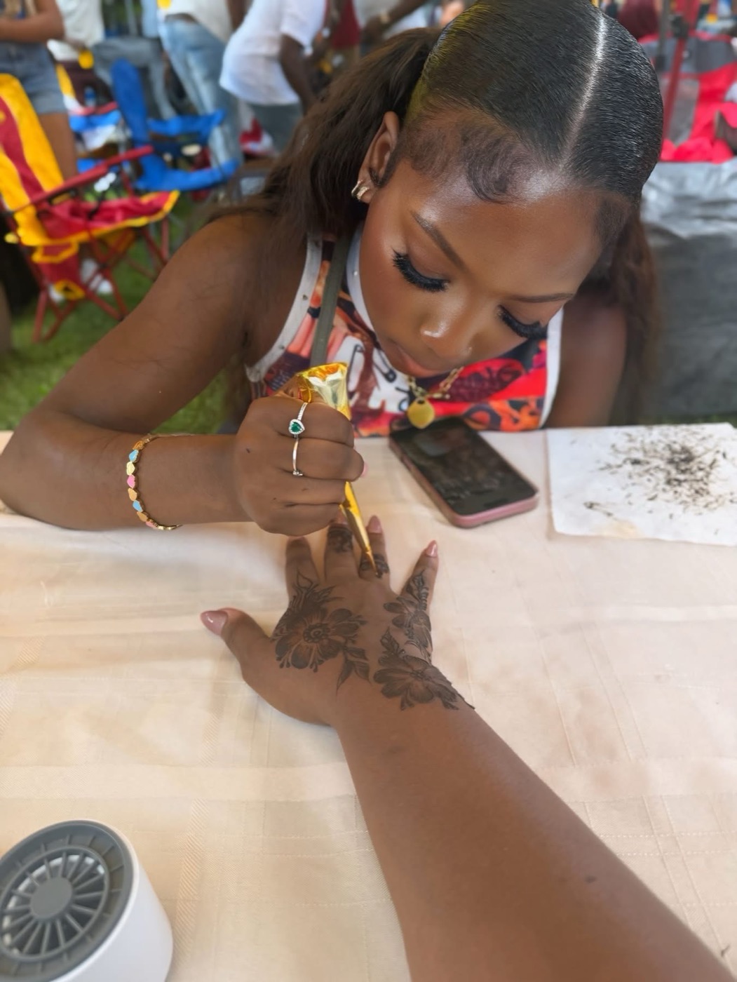 Kaylyn Davis creating henna tattoos for donors to the scholarship fund